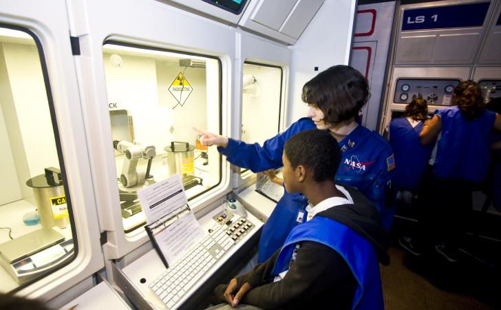 Boy learning about space from woman