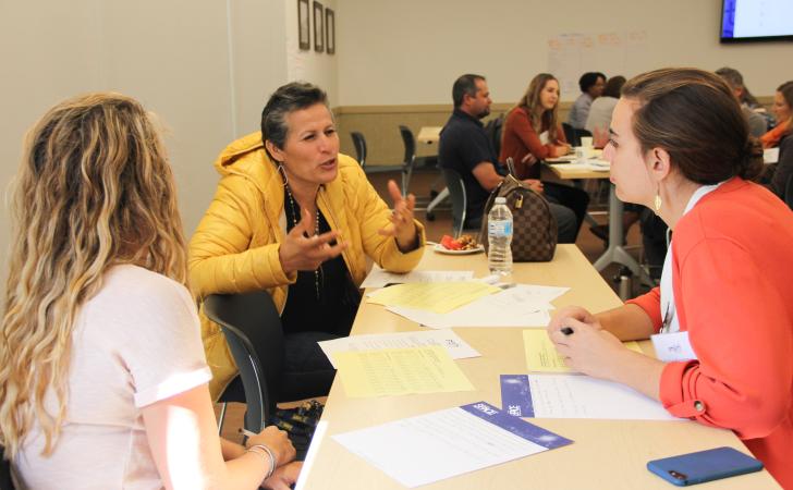 Woman emphatically communicating to her table companions 